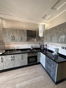 a kitchen with black counters and stainless steel appliances at RAWAN RESIDENCY in Oujda