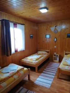 een kamer met 2 bedden en een raam bij Korondi Kulcsosházak in Corund