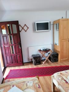 a living room with a red door and a table at Korondi Kulcsosházak in Corund