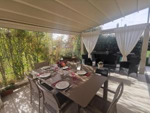 a dining table and chairs on a patio at R&B Il Melograno in Formigine