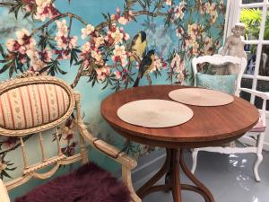 ein Tisch und zwei Stühle in einem Zimmer mit Blumen in der Unterkunft VILLA EVA in Bray-Dunes