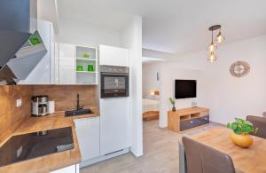 een keuken en een woonkamer met witte kasten en een tafel bij Apartments Cvijeta in Dubrovnik