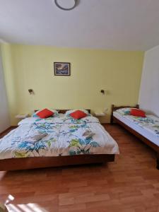 a bedroom with two beds with red pillows at Country House Fon in Kobarid