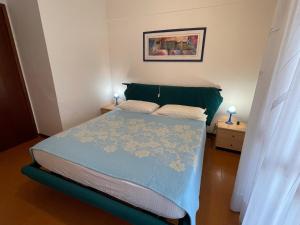 a small bedroom with a bed and two night stands at Residence Solarium Qua in Bibione