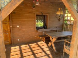 a porch of a log cabin with a wooden bench at Arbatinės apartamentai - Močiutės namelis in Biržai