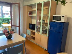 a kitchen with a blue refrigerator with a microwave on top at Residence Solarium Qua in Bibione