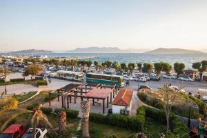 a parking lot next to the ocean with cars parked at Togias Hotel in Aegina Town