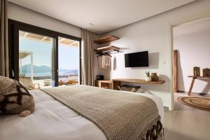 a bedroom with a large bed and a tv at Dot Milos in Adamantas