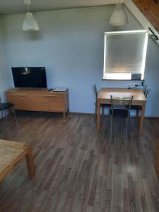 Habitación con mesa, sillas y TV. en Vinland Cottage, en Egilsstadir