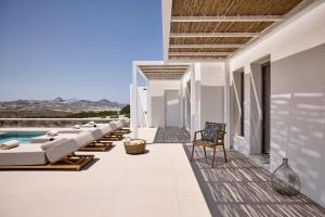 a patio with lounge chairs and a swimming pool at Dot Milos in Adamantas