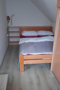 1 dormitorio con 1 cama con marco de madera en Apartment Pr Dev, en Begunje na Gorenjskem