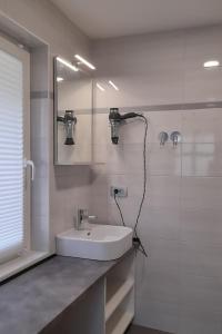 a white bathroom with a sink and a mirror at Apartment Pr Dev in Begunje na Gorenjskem +6 photos