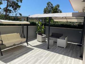 un patio con ombrellone, sedie e divano di Appartamenti Sole&Mare a Polignano a Mare