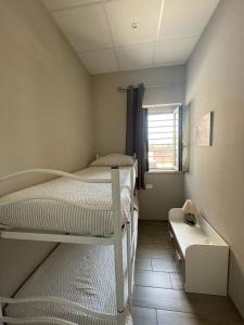 a small bedroom with a bunk bed and a window at Appartamenti Sole&Mare in Polignano a Mare