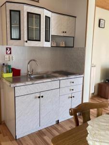 a kitchen with white cabinets and a sink and a table at Country House Fon in Kobarid