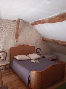 ein Schlafzimmer mit einem Holzbett im Dachgeschoss in der Unterkunft Maisonnette de Mamie in Pouilly-en-Auxois
