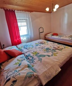 a bedroom with a bed with a floral bedspread and a window at Country House Fon in Kobarid