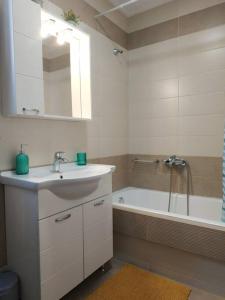 ein Badezimmer mit einem Waschbecken und einer Badewanne mit einem Spiegel in der Unterkunft StelisIoanna in Chania