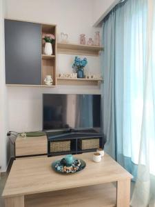 ein Wohnzimmer mit einem TV und einem Tisch in der Unterkunft StelisIoanna in Chania