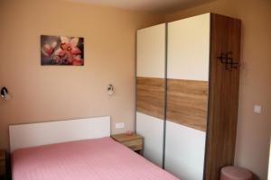 1 dormitorio con 1 cama rosa y armario en МОЯТ РАЙ - ПАДАЛОТО, en Smolyan