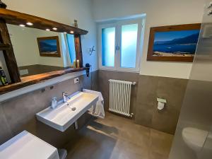 a bathroom with a sink and a mirror at Lago Lodge Claudia in Domaso +14 photos