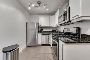 a kitchen with white cabinets and stainless steel appliances at Charming 2BD in Hip Neighborhood - 3 Blks to Metro in Washington