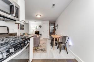 Charming 2BD in Hip Neighborhood - 3 Blks to Metro في واشنطن: مطبخ وغرفة معيشة مع موقد وطاولة