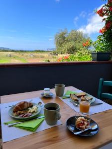 een tafel met twee borden eten en twee kopjes koffie bij Agriturismo Graziano e Barbara in Porto Conte