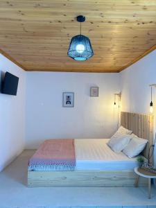 a bedroom with a bed with a wooden ceiling at Stegna Rita's apartment in Archangelos