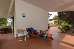 eine Terrasse mit einem Sofa, einem Stuhl und einem Tisch in der Unterkunft * * * Cypress Villa * * * {Free Parking} in Giglio Porto