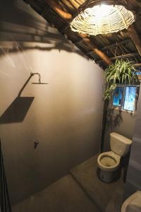 a bathroom with a toilet and a plant on the wall at Kali Village in Acapulco