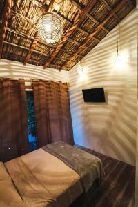 a bedroom with a bed and a flat screen tv at Kali Village in Acapulco