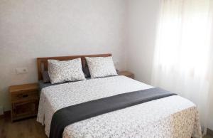 a bedroom with a bed with white sheets and a window at Apartamento Tubal in Bossost
