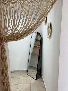 a mirror in a room with a curtain at Stegna Rita's apartment in Archangelos