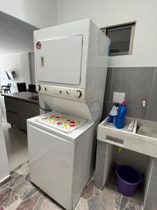 a white refrigerator with a childs play kitchen at Espectacular apartamento central in Montería