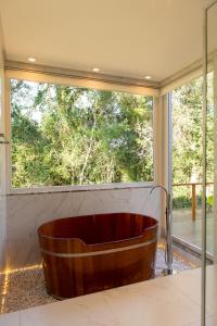 baño con bañera grande y ventana en Jardim das Pipas, en Garibaldi