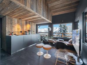 a kitchen with a counter and some chairs and a table at Appartement Courchevel 1850, 3 pièces, 6 personnes - FR-1-564-83 in Courchevel