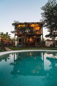 a house with a large swimming pool in front of it at Kali Village in Acapulco