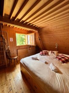a bedroom with a bed in a wooden cabin at ~Chalet_Rifugio tra i boschi~ in Sella Nevea