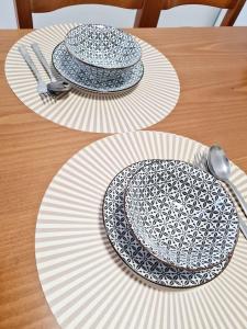 2 platos en una mesa de madera con utensilios de plata en Nàra house 2, en Artemida