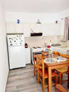 Il comprend une cuisine équipée d'une table et d'un réfrigérateur blanc. dans l'établissement Nàra house 2, à Artemi