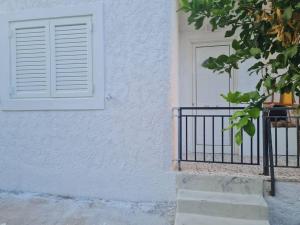 une maison blanche avec une fenêtre et une clôture dans l'établissement Nàra house 2, à Artemi