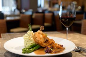 un plato blanco de comida con una copa de vino en Sheraton Suites Orlando Airport Hotel, en Orlando