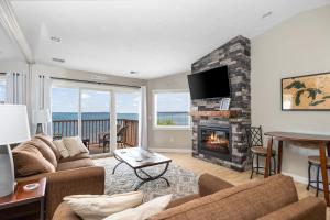 a living room with a couch and a fireplace at Beachside 329 Waterfront Condo in Traverse City