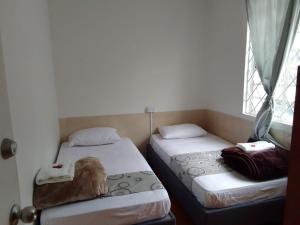two beds sitting in a room with a window at casa coral in Bogotá