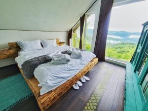 ein Schlafzimmer mit einem Bett mit Handtüchern und Schuhen darauf in der Unterkunft Emoția Munților 