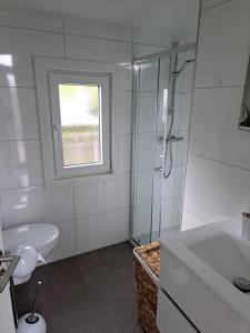 a bathroom with a shower and a toilet and a sink at Heimathafen in Lathum