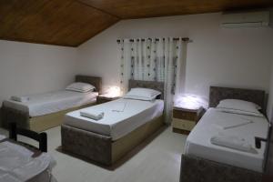 a bedroom with two beds and two tables and chairs at Guest House Bumbli in Berat