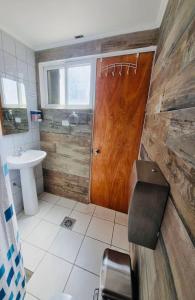a bathroom with a wooden door and a sink at CASA TAMBO in San Pedro de Atacama