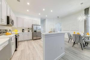 a kitchen with white cabinets and a dining room at 596 Modern 5 bed home overlooking beautiful golf course and conservation with Games room in Davenport